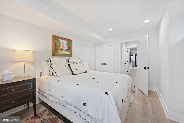 bedroom with light wood finished floors, baseboards, a closet, and recessed lighting