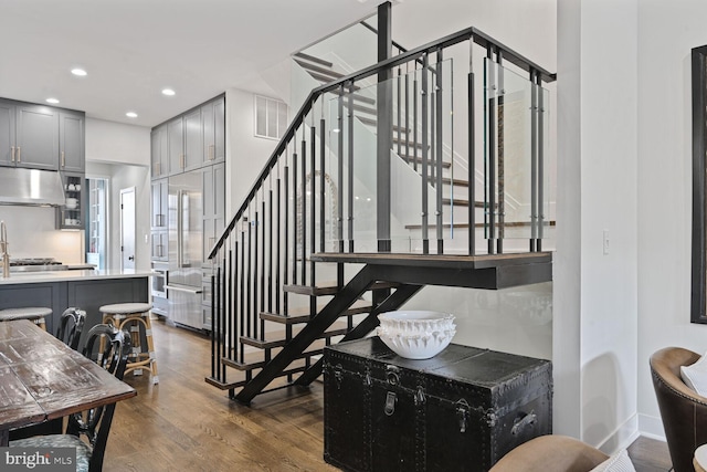 stairs featuring recessed lighting, visible vents, baseboards, and wood finished floors