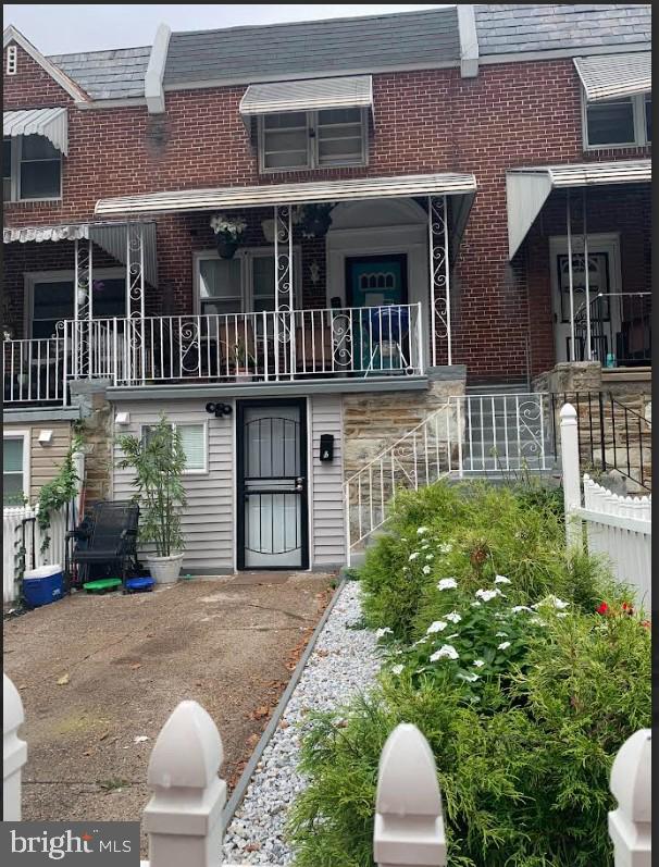 back of property with brick siding and a high end roof