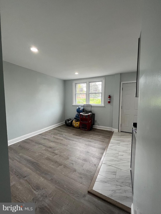 interior space featuring recessed lighting, marble finish floor, and baseboards