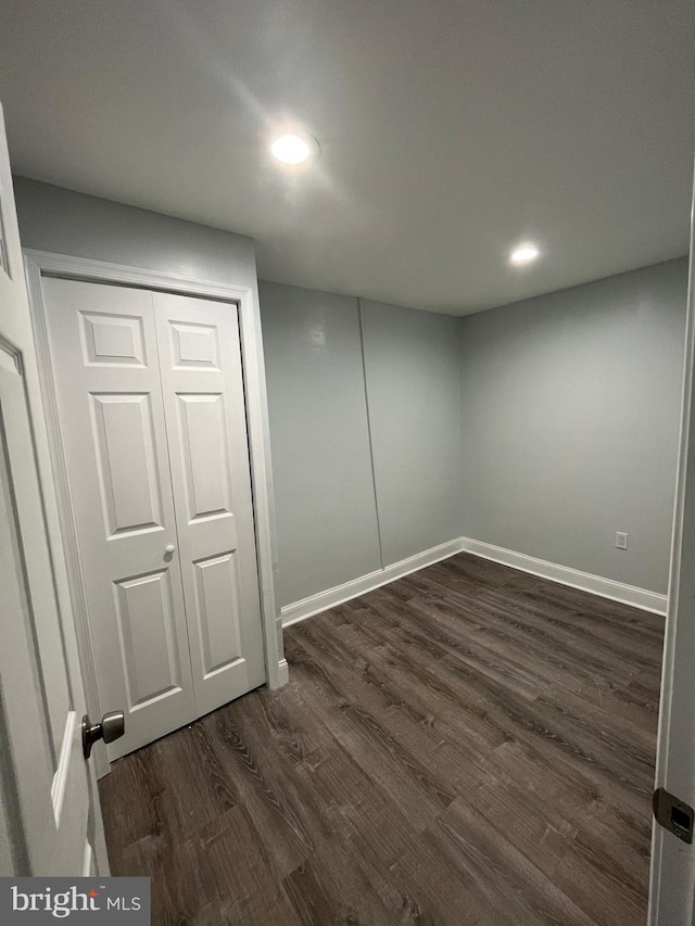 below grade area featuring baseboards, dark wood finished floors, and recessed lighting