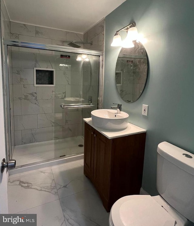 full bath featuring toilet, marble finish floor, a stall shower, and vanity