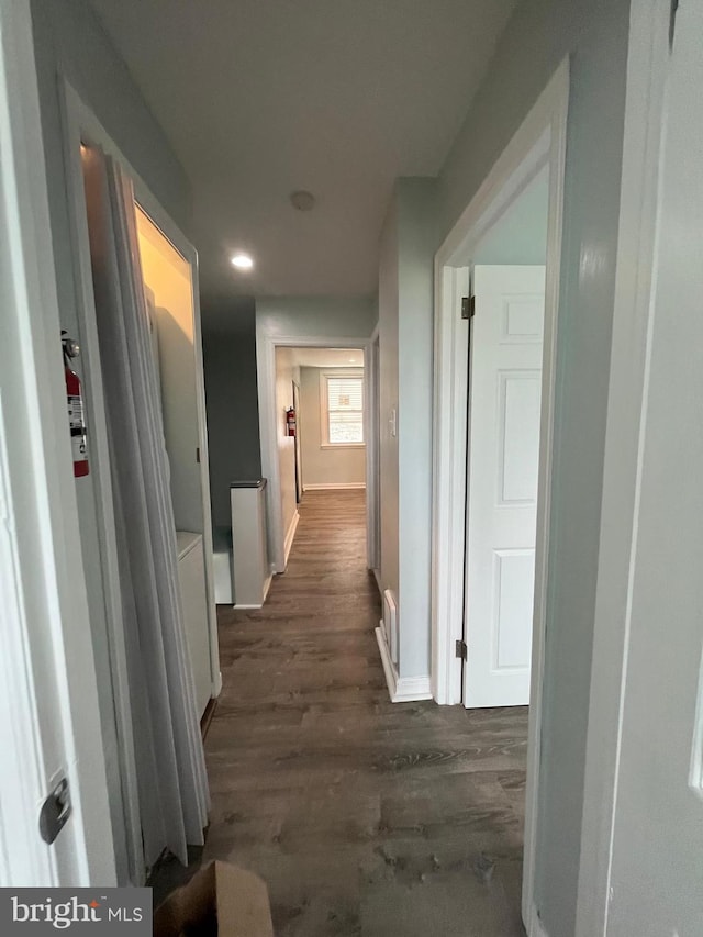 hallway featuring dark wood-style flooring, recessed lighting, and baseboards