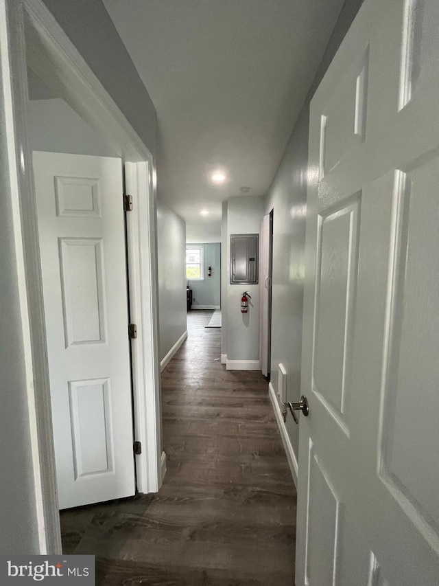 hall featuring dark wood-style flooring and baseboards