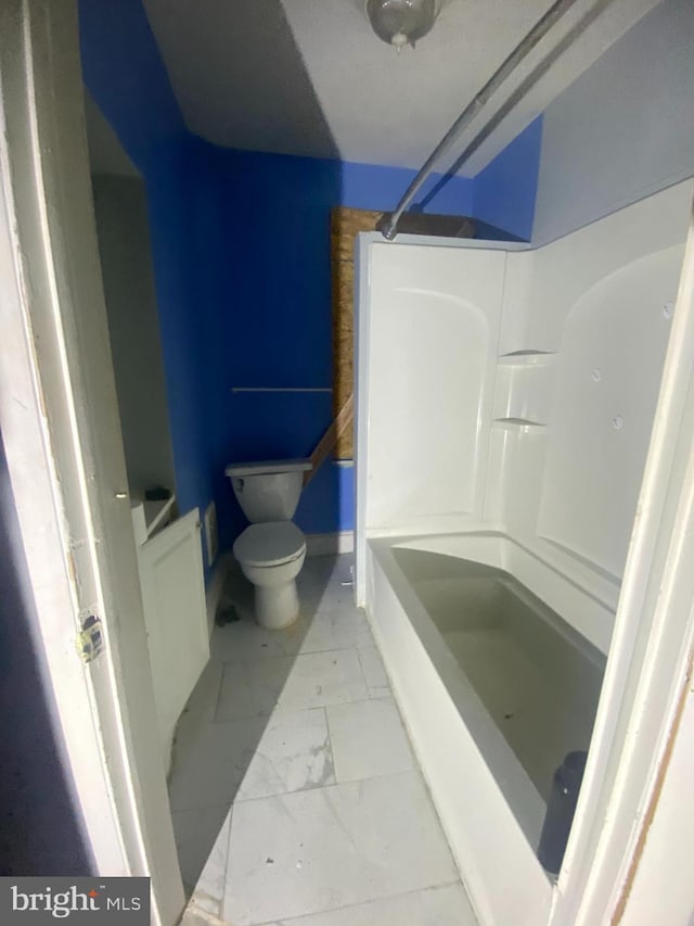 bathroom featuring marble finish floor, a shower, and toilet