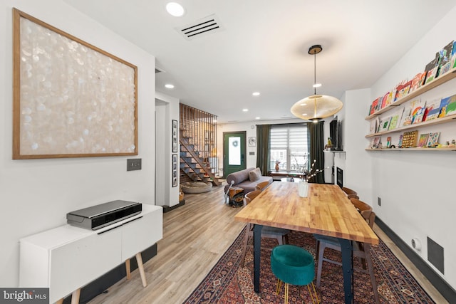 dining space with light wood-style floors, stairs, recessed lighting, baseboards, and visible vents