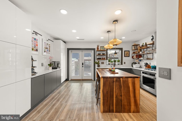 kitchen featuring modern cabinets, open shelves, white cabinets, wood counters, and oven