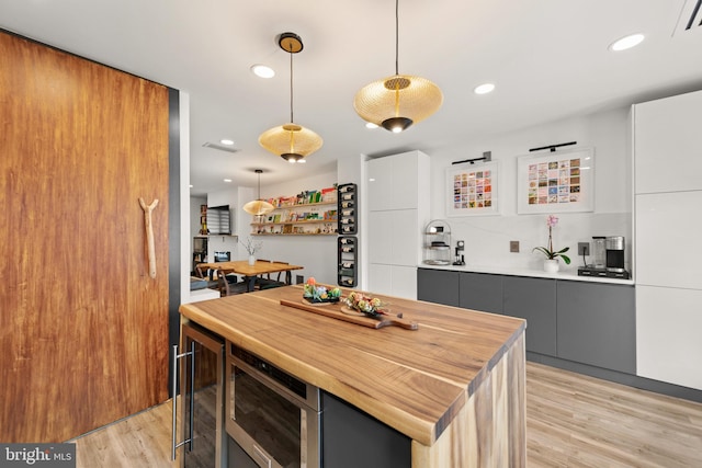 kitchen featuring wooden counters, hanging light fixtures, modern cabinets, light wood-type flooring, and gray cabinetry