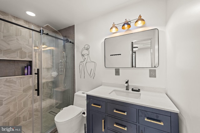 bathroom featuring vanity, a stall shower, and toilet