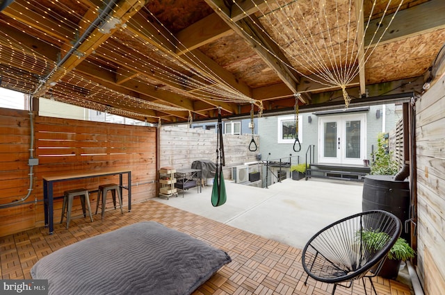 view of patio / terrace featuring french doors, outdoor dry bar, and fence