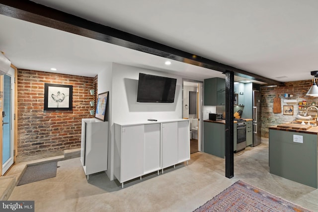 unfurnished living room with finished concrete floors, recessed lighting, and brick wall
