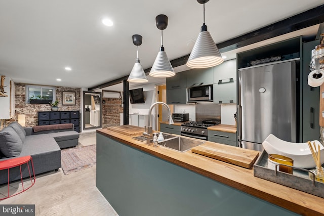 kitchen with stainless steel appliances, decorative light fixtures, butcher block countertops, and brick wall
