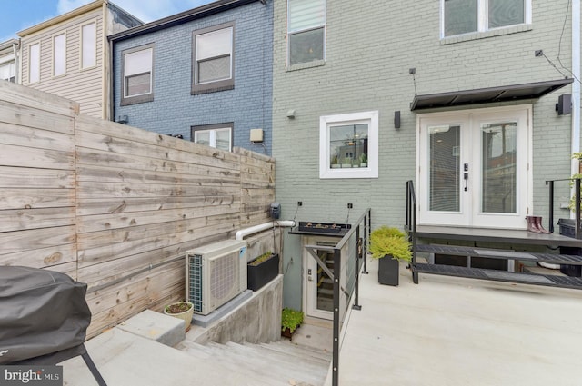 rear view of house with fence, a patio, french doors, and brick siding