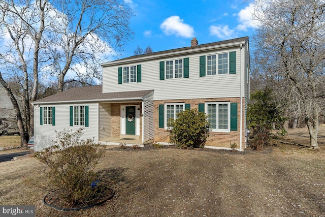 view of front of home with brick siding and a chimney