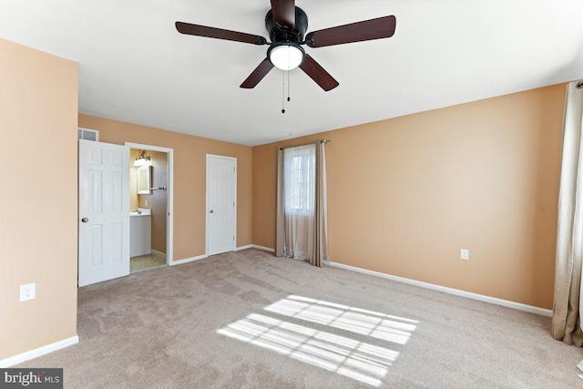 unfurnished bedroom with carpet flooring, connected bathroom, baseboards, and ceiling fan