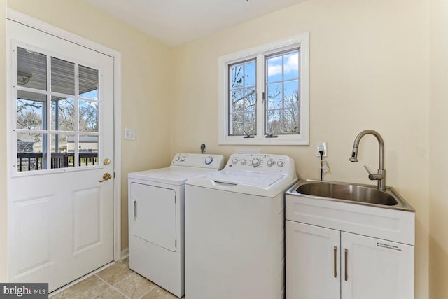 washroom featuring a healthy amount of sunlight, a sink, cabinet space, and washer and dryer