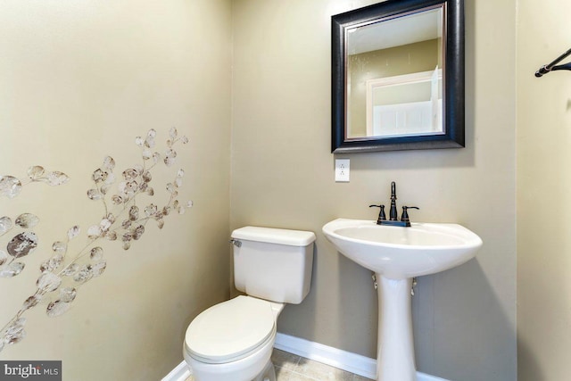 bathroom with toilet and baseboards