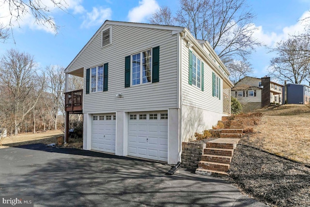 view of property exterior featuring driveway and an attached garage