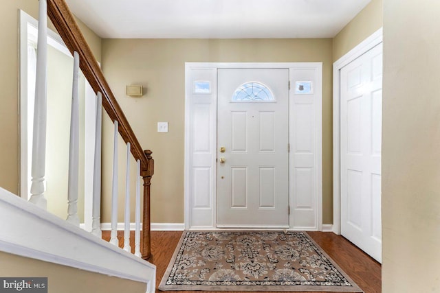 entrance foyer with stairs, baseboards, and wood finished floors