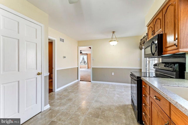 kitchen with light stone counters, brown cabinets, visible vents, plenty of natural light, and black appliances