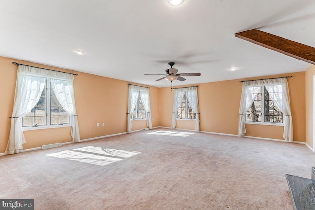 unfurnished living room featuring carpet floors, baseboards, visible vents, and ceiling fan