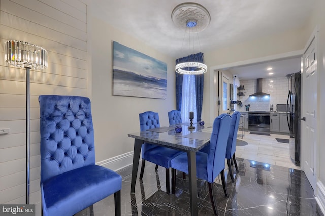 dining space featuring marble finish floor and baseboards