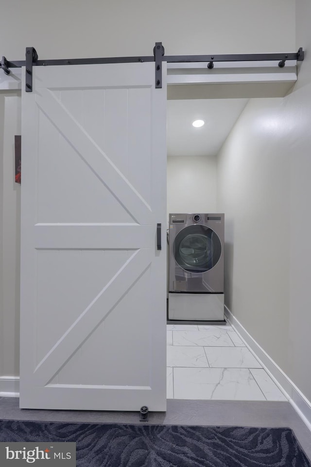 laundry room with marble finish floor, washer / clothes dryer, a barn door, laundry area, and baseboards