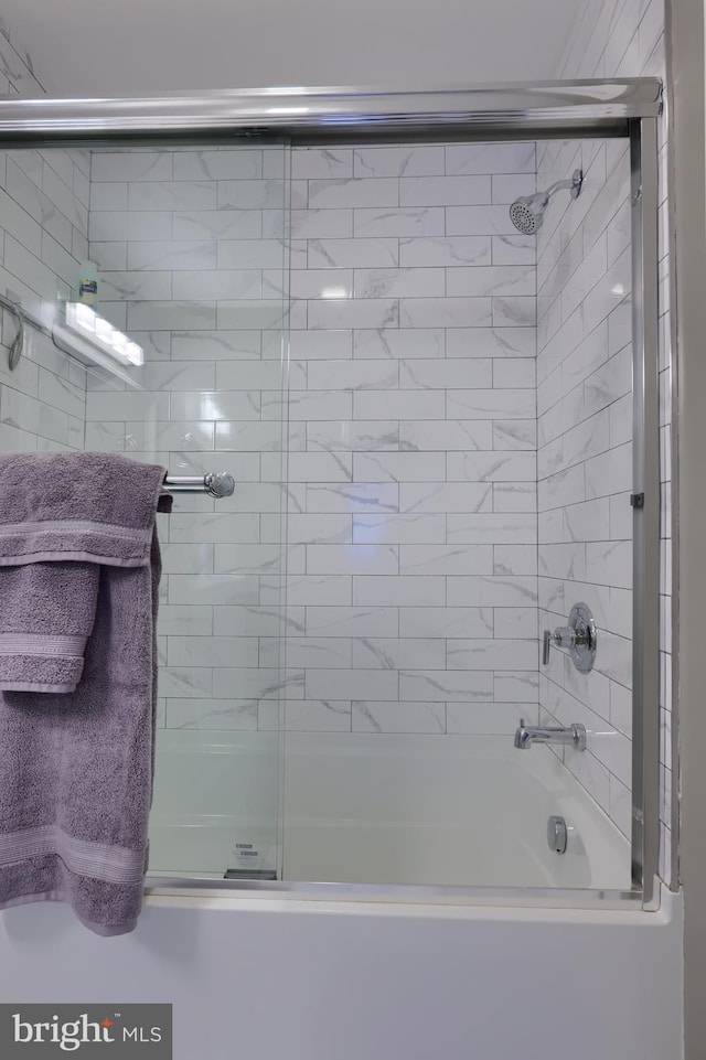 bathroom with bath / shower combo with glass door