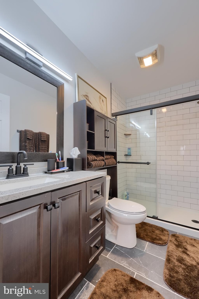 bathroom featuring vanity, a shower stall, and toilet