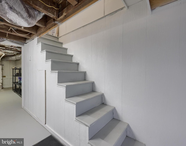 stairway featuring finished concrete floors