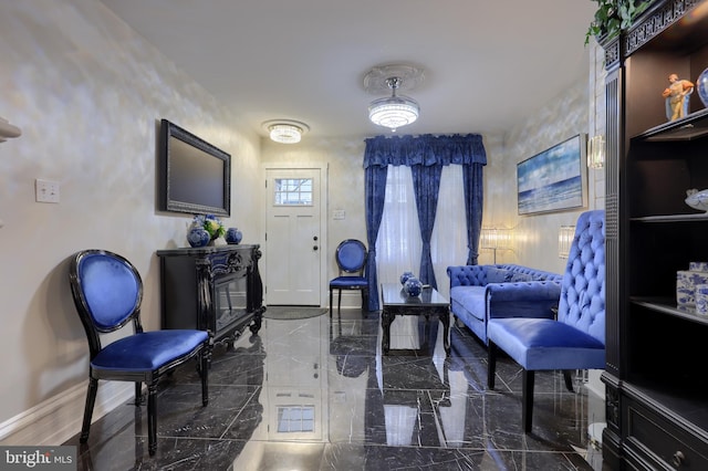 living area featuring marble finish floor and baseboards