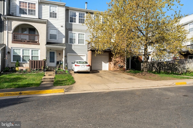 multi unit property featuring driveway, a garage, and brick siding