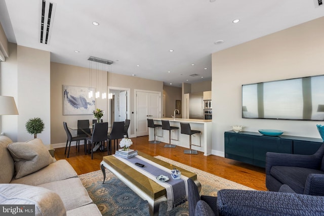 living room featuring baseboards, wood finished floors, and recessed lighting