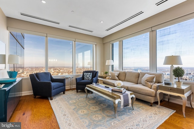 living area with a healthy amount of sunlight, visible vents, and wood finished floors