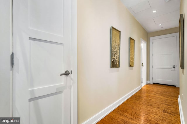 hallway featuring recessed lighting, light wood-style flooring, and baseboards