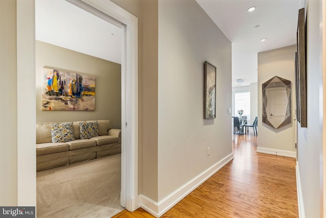 corridor with baseboards, recessed lighting, and light wood-style floors