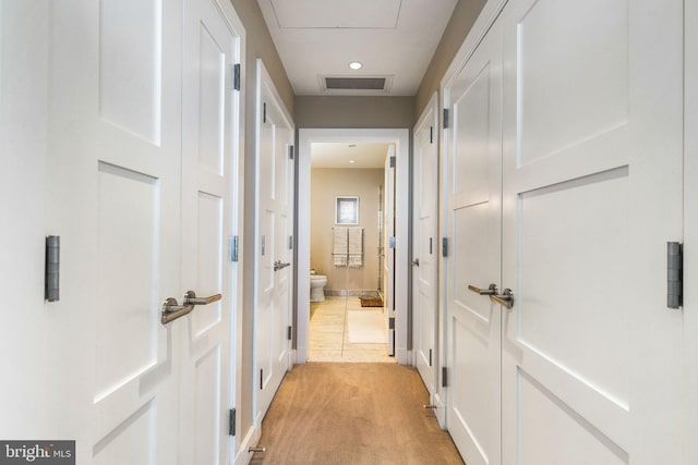 corridor featuring visible vents and light colored carpet