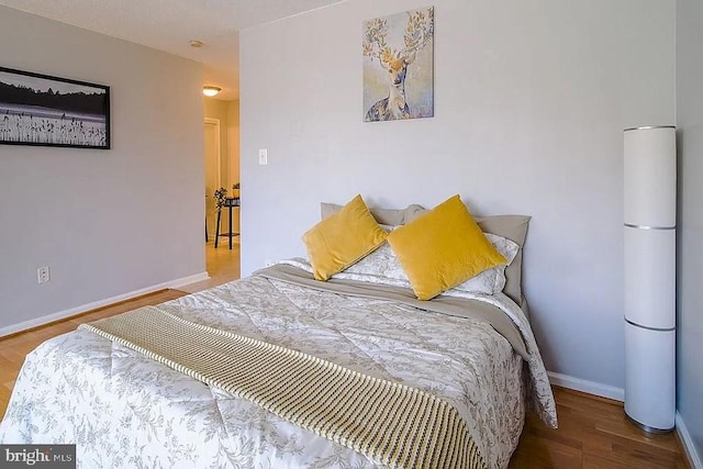 bedroom featuring baseboards and wood finished floors