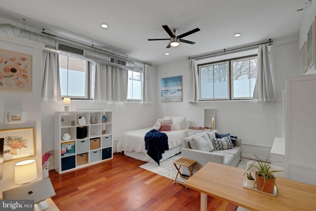 bedroom featuring a ceiling fan, recessed lighting, visible vents, and wood finished floors