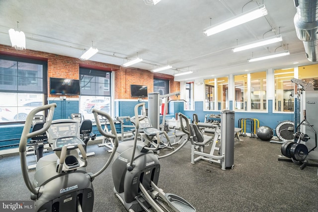 exercise room featuring brick wall