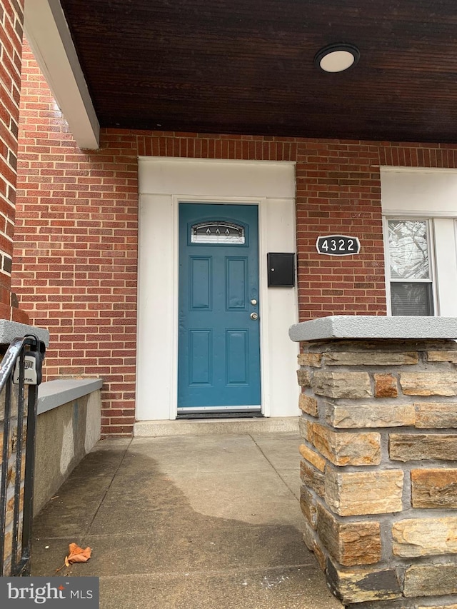 doorway to property featuring brick siding