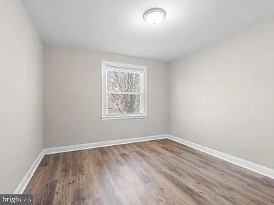 unfurnished room featuring baseboards and wood finished floors