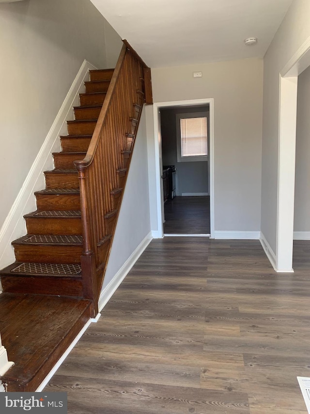 stairs featuring baseboards and wood finished floors