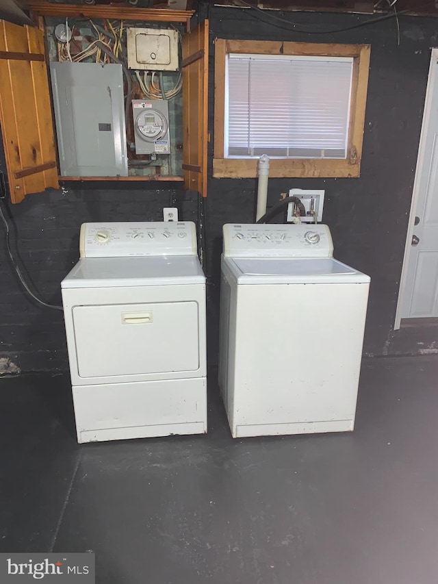 washroom featuring laundry area, electric panel, and washing machine and clothes dryer