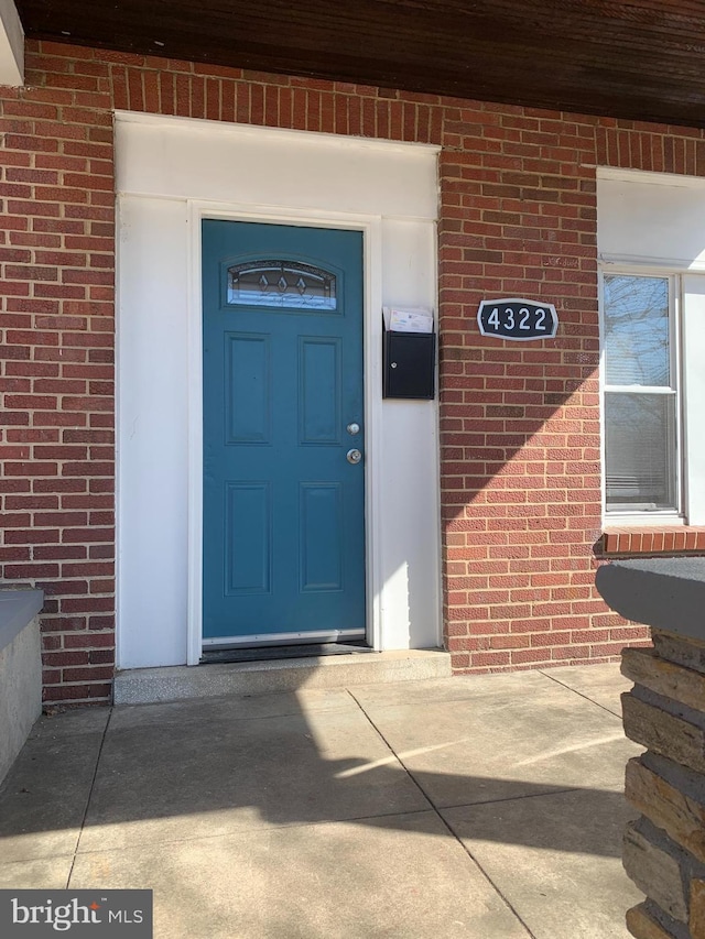 entrance to property featuring brick siding