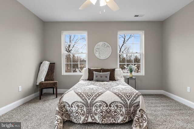 carpeted bedroom featuring visible vents, baseboards, and multiple windows