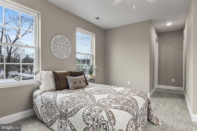 bedroom with a ceiling fan, carpet flooring, visible vents, and baseboards