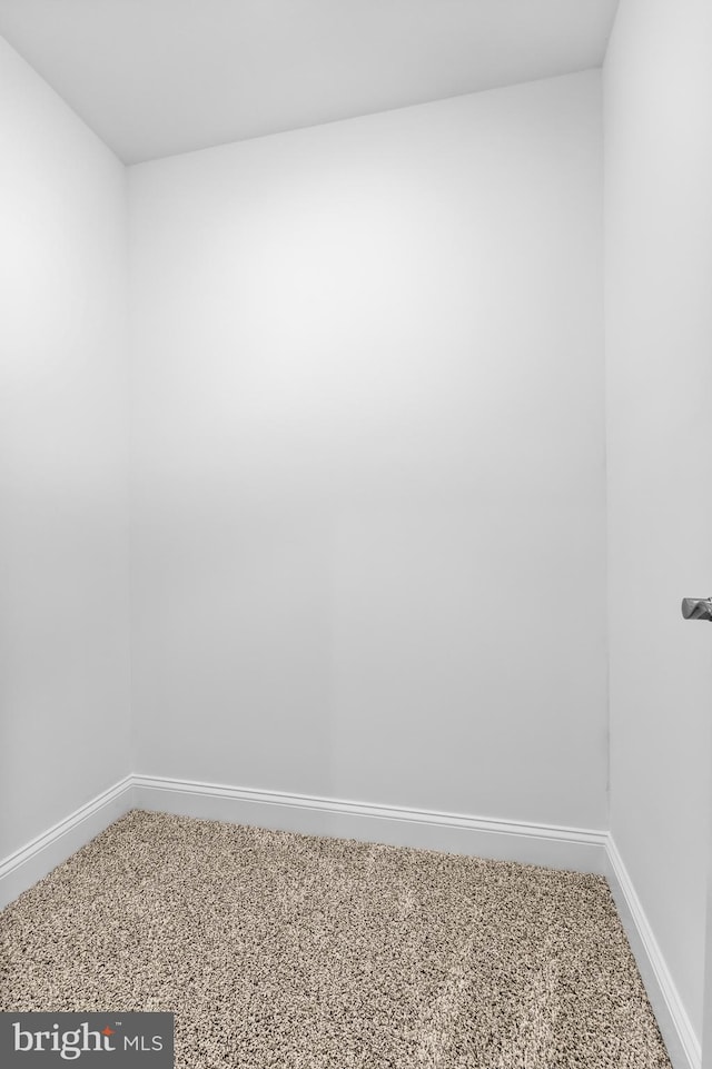 empty room featuring carpet and baseboards