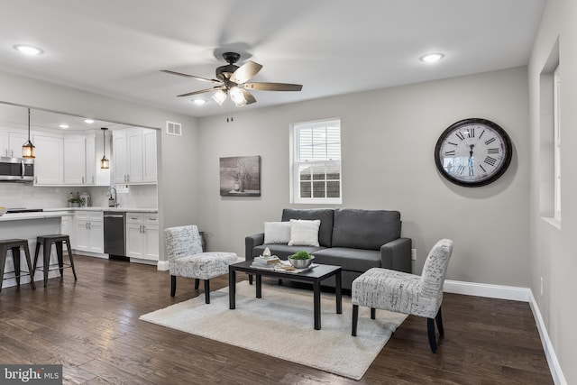 living room featuring baseboards, visible vents, a ceiling fan, dark wood-style flooring, and recessed lighting