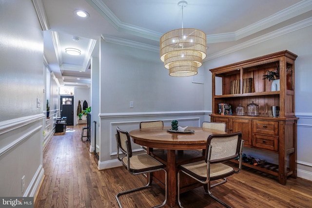 dining room featuring dark wood-type flooring, a decorative wall, and ornamental molding